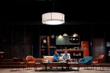 due interpreti seduti sul divano nel salone di casa