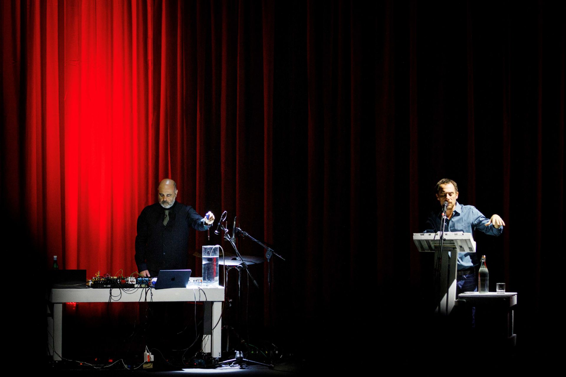 Elio Germano su di un palcoscenico privo di scenografie con davanti un leggio interpreta un testo