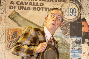 Gianfelice Imparato con sguardo stupito guarda di lato con cappello stretto in mano