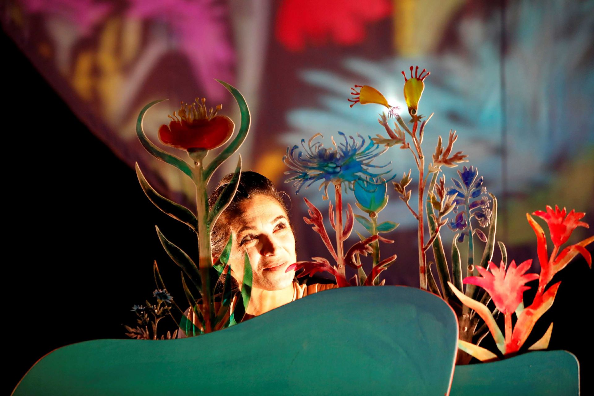 volto di donna tra fiori cartonati e onde verdi