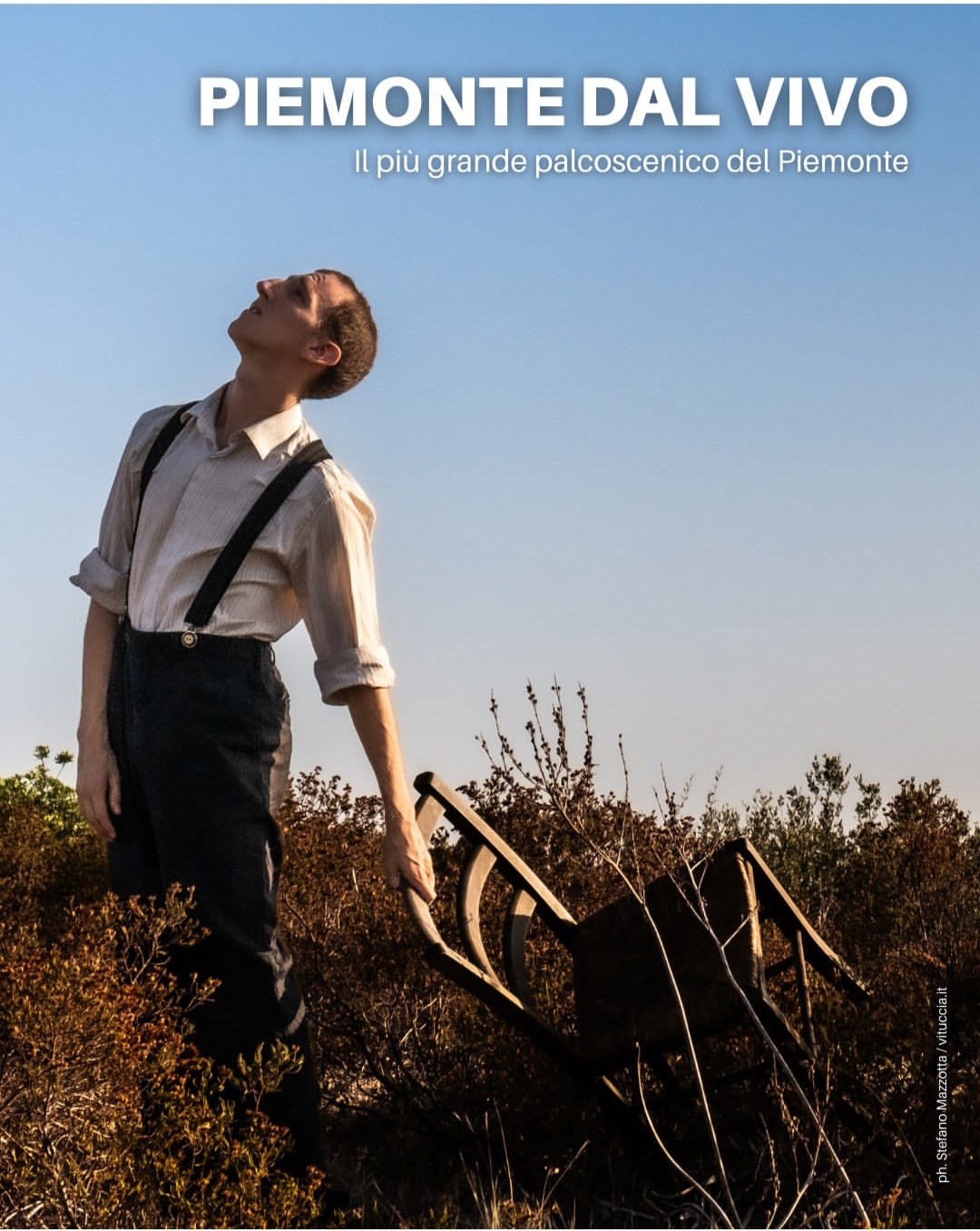 uomo con sedia guarda al cielo in mezzo ad un campo